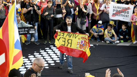 Un hombre con una bandera de España durante la manifestación que bajo los lemas "Autodeterminación no es delito" y "Democracia es decidir" ha sido convocada por más de sesenta colectivos sociales, organizaciones del 15M, entidades republicanas y antif