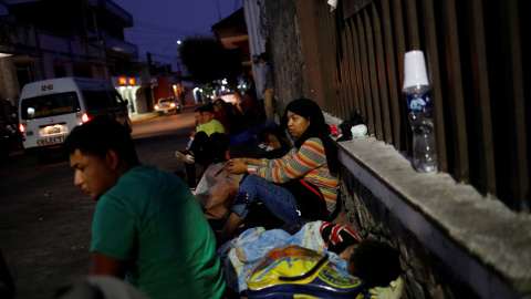 Las familias descansan a la intemperie a la espera de ingresar a la Comisión Mexicana de Asistencia para Refugiados (COMAR). / Reuters