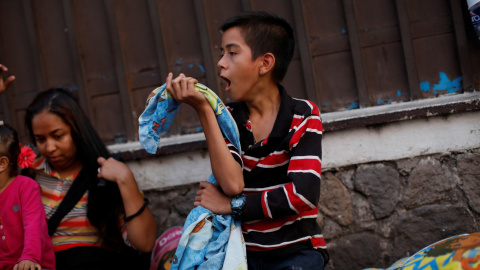 Un niño hondureño bosteza después de dormir en el suelo mientras espera en la fila para ingresar a la Comisión Mexicana de Asistencia para Refugiados (COMAR). / Reuters