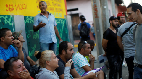 Los migrantes cubanos conversan mientras esperan en la fila para ingresar a la Comisión Mexicana de Asistencia a Refugiados (COMAR). / Reuters