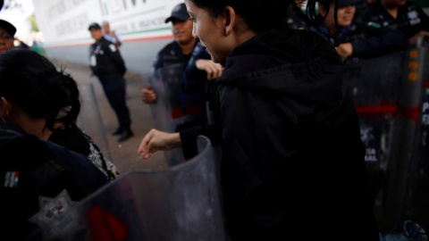 Una migrante cubana pasa entre los oficiales de la Policía Federal Mexicana mientras huye de las instalaciones de migración Siglo XXI en Tapachula. / Reuters
