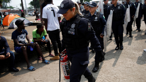 Miembros de la Policía Federal Mexicana caminan hacia las instalaciones de migración de Siglo XXI en Tapachula, México. / Reuters