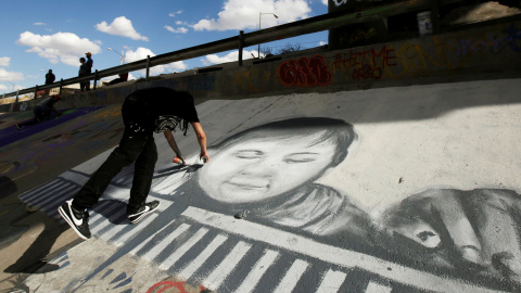 El artista Ricardo Uribe trabaja en un graffiti para resaltar los problemas de inmigración que rodean la frontera y unir el arte y la cultura en Ciudad Juárez, México. / Reuters