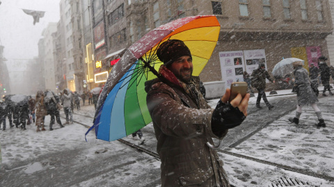 Un vendedor ambulante de paragüas se hace una selfie mientras nieva en la principal calle peatonal en el centro de Estambul./REUTERS-Murad Sezer