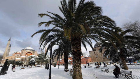 Un turista se sienta en un banco en la Plaza de la Mezquita cubierta por un gran manto blanco en el centro histórico de la ciudad de Estambul./REUTERS-Murad Sezer