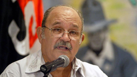 Miguel D'Escoto, ofreciendo una charla delante de la bandera del Frente Sandinista de Liberación Nacional y la imagen del líder nicaragüense Augusto Sandino. Miguel D'Escoto, ofreciendo una charla delante de la bandera del Frente Sandinista de Liberación Nacional y la imagen del líder nicaragüense Augusto Sandino.
