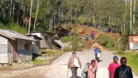 Varias personas caminan con sus pertenencias tras el desprendimiento de tierra en Kaokalam, en Papúa Nueva Guinea. Varias personas caminan con sus pertenencias tras el desprendimiento de tierra en Kaokalam, en Papúa Nueva Guinea.