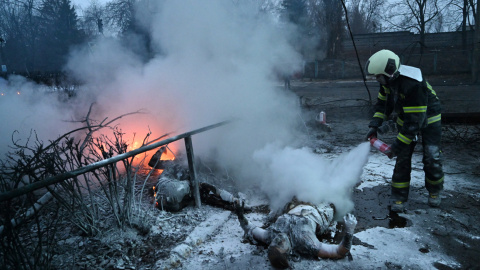 Un bombero extingue el fuego sobre los cuerpos de dos transeúntes que murieron en el bombardeo ruso contra la torre de televisión de Kiev el 1 de marzo.