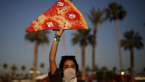 La pizza, alimento de los festivales en el Coachella. Una mujer posa con una réplica gigante.