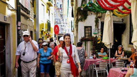 Guía turística dirige a unos turistas por las calles de Lisboa AFP / PATRICIA DE MELO MOREIRA Guía turística dirige a unos turistas por las calles de Lisboa AFP / PATRICIA DE MELO MOREIRA