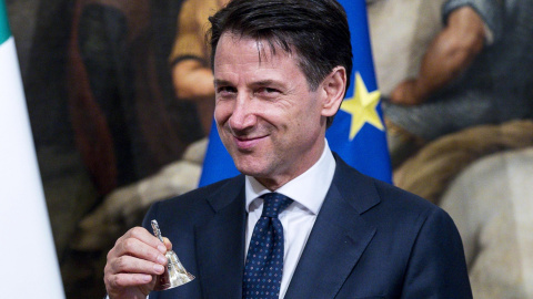 El nuevo primer ministro italiano, Giuseppe Conte, posa con una pequeña campana de plata entregada por el ahora exprimer ministro Paolo Gentiloni (no aparece) para abrir el primer Consejo de Ministros en el Palacio de Chigi, en Roma. EFE El nuevo primer ministro italiano, Giuseppe Conte, posa con una pequeña campana de plata entregada por el ahora exprimer ministro Paolo Gentiloni (no aparece) para abrir el primer Consejo de Ministros en el Palacio de Chigi, en Roma. EFE