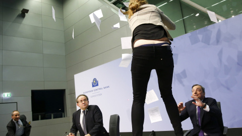 Una joven se sube a la mesa donde estaba Mario Draghi. /REUTERS