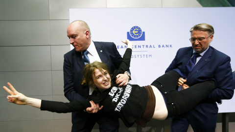 La joven, sonriente, hace la V con los dedos mientras es retirada por dos guardaespaldas. /REUTERS