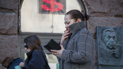 Una mujer rusa pasa junto a un panel que muestra el signo del dólar en una oficina de cambio en Moscú. Una mujer rusa pasa junto a un panel que muestra el signo del dólar en una oficina de cambio en Moscú.