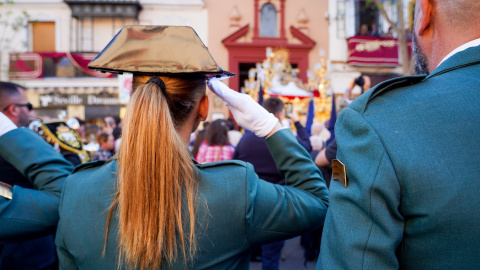 Una agente de la Guardia Civil saluda la salida del paso de La Piedad de la Hermandad del Baratillo, en Sevilla. E.P./Eduardo Briones Una agente de la Guardia Civil saluda la salida del paso de La Piedad de la Hermandad del Baratillo, en Sevilla. E.P./Eduardo Briones