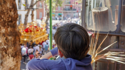 Un niño viendo desde un balcón el cortejo de la Hermandad de la Sed, en Sevilla. E.P./Eduardo Briones Un niño viendo desde un balcón el cortejo de la Hermandad de la Sed, en Sevilla. E.P./Eduardo Briones