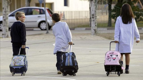 Dos niños y una niña, camino del colegio./ EFE Dos niños y una niña, camino del colegio./ EFE