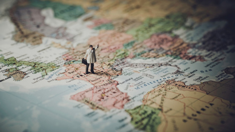 La figura de un hombre se apoya sobre un mapa de Europa La figura de un hombre se apoya sobre un mapa de Europa