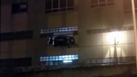 Una mujer atraviesa la pared de un edificio con su coche Una mujer atraviesa la pared de un edificio con su coche