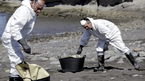 Personal de limpieza se encuentra desde esta mañana recogiendo el petroleo que ha llegado en las últimas horas a la playa de Venegueras, en el municipio grancanario de Mogán. EFE