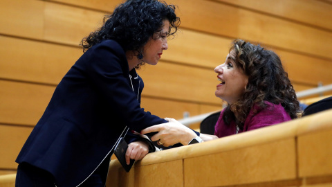 La ministra de Hacienda, María Jesús Montero, conversa con la senadora de Podemos, María Isabel Mora Grande, durante la sesión del Senado que debate los cinco vetos a los PGE de 2018. EFE/Juan Carlos Hidalgo La ministra de Hacienda, María Jesús Montero, conversa con la senadora de Podemos, María Isabel Mora Grande, durante la sesión del Senado que debate los cinco vetos a los PGE de 2018. EFE/Juan Carlos Hidalgo