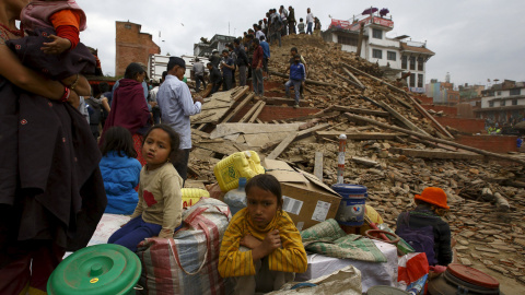 La gente se sienta con sus pertenencias junto a los escombros de un templo dañado de la Plaza Durbar Bashantapur Plaza, tras el gran terremoto que golpeó Katmandú, Nepal.- REUTERS / Navesh Chitrakar