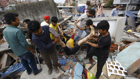 La gente lleva el cuerpo de una víctima de una casa dañada después de un terremoto, en Katmandú, Nepal.- REUTERS / Navesh Chitrakar