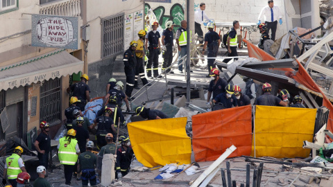 Efectivos de la Unidad Militar de Emergencia (UME) y los Bomberos recuperan el cadáver de una mujer que ha sido localizado entre los escombros del edificio que se ha derrumbado en la localidad tinerfeña de Los Cristianos, en el municipio de