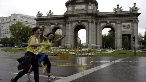 Dos participantes en el maratón de Madrid, a su paso por la Puerta de Alcalá. /Angel Díaz (EFE)