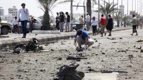 Un hombre registra los restos tras un ataque con coche bomba frente al Ministerio de Asuntos Exteriores en la ciudad yemení de Adén. REUTERS/Fawaz Salman