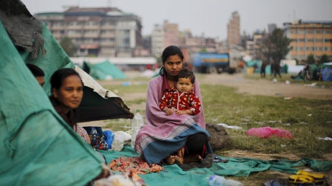 Una víctima del terremoto lleva en brazos a su hermana fuera de su refugio improvisado en las afueras de Katmandú, Nepal./ REUTERS/Adnan Abidi