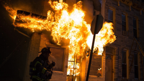 Los bomberos acuden a extinguir las llamas en un edificio durante los disturbios provocados en una protesta contra la muerte de Freddie Gray en Baltimore. EFE