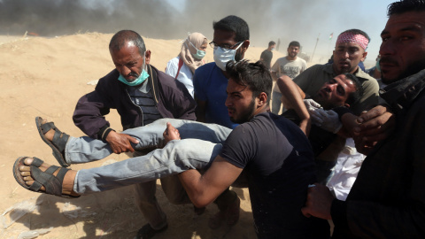 Varias personas trasladan un hombre herido durante las protestas del lunes en Gaza. - REUTERS Varias personas trasladan un hombre herido durante las protestas del lunes en Gaza. - REUTERS