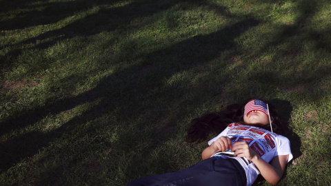Una niña se duerme con una bandera de Estados Unidos sobre su cara durante un acto del candidato demócrata a la presidencia de los Estados Unidos, Bernie Sanders. REUTERS/Lucas Jackson