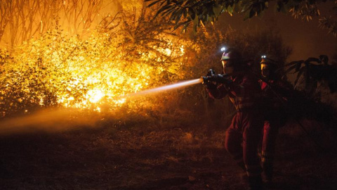 Efectivos de la Unidad Militar de Emergencias (UME) trabajan en la extinción del incendio forestal declarado ayer por la tarde en el municipio de Verín que obligó a activar la alerta por "situación 2" por proximidad a núcleos poblados y a c
