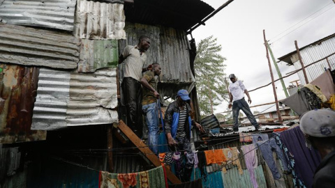 Simpatizantes del líder opositor Raila Odinga subidos al tejado de una casa poniéndose a salvo del fuego.EFE/Daniel Irungu
