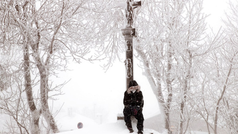 Un chico se sienta a los pies del Cruceiro de O Cebreiro en Lugo, que da entrada al Camino de Santiago en Galicia, cubierto por la nieve. Un chico se sienta a los pies del Cruceiro de O Cebreiro en Lugo, que da entrada al Camino de Santiago en Galicia, cubierto por la nieve.