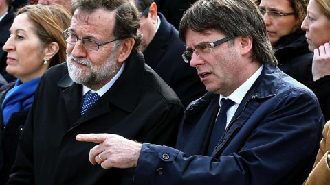 El jefe del Ejecutivo, Mariano Rajoy, y el presidente de la Generalitat, Carles Puigdemont (d), encabezan el acto de homenaje a las víctimas del accidente del vuelo Germanwings 9525, celebrado hoy en el aeropuerto de El Prat en la víspera d El jefe del Ejecutivo, Mariano Rajoy, y el presidente de la Generalitat, Carles Puigdemont (d), encabezan el acto de homenaje a las víctimas del accidente del vuelo Germanwings 9525, celebrado hoy en el aeropuerto de El Prat en la víspera d