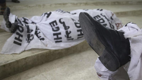 Los cuerpos de los policías en el depósito tras ser tiroteados por varios agresores en Karachi, Pakistán. EFE