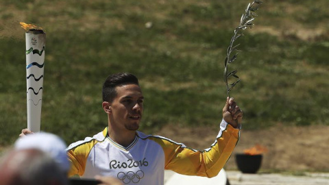 El campeón del mundo de gimnasia griego Lefteris Petrounias porta la antorcha olímpica. /EFE