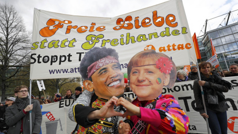 Dos manifestantes se disfrazan de Obama y Merkel, en protesta contra el tratado comercial entre EEUU y la Unión Europea. REUTERS/Kai Pfaffenbach