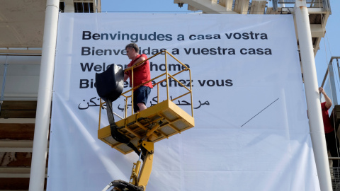 Un voluntario de la Cruz Roja coloca una pancarta para saludar a los migrantes del Aquarius en el puerto de Valencia. REUTERS/Heino Kalis Un voluntario de la Cruz Roja coloca una pancarta para saludar a los migrantes del Aquarius en el puerto de Valencia. REUTERS/Heino Kalis