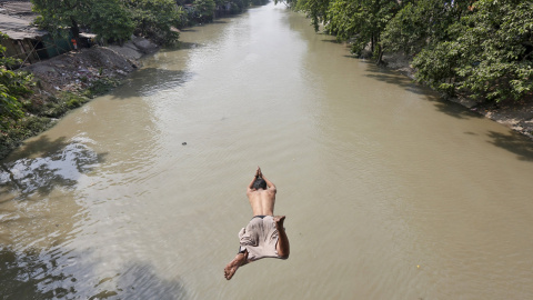 Un hombre salta a un rio para refrescarse en un día caluroso en Calcuta. REUTERS/Rupak De Chowdhuri