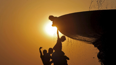 Unos niños cuelgan de una fuente en Nueva New Delhi, India. REUTERS/Anindito Mukherjee