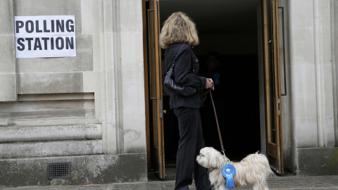 Un perro junto a su dueña esperan frente a un colegio electoral para votar. Los británicos votan este jueves para elegir a los 650 miembros del Parlamento y decidir el signo del nuevo Gobierno en unos comicios presididos por la incertidumbr