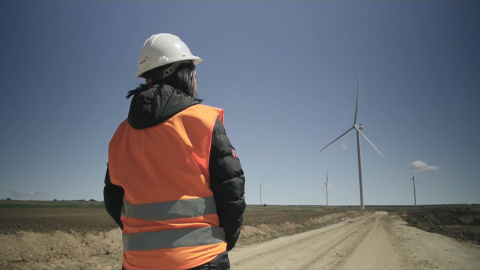 Mujer de espaldas con molinos de fondo