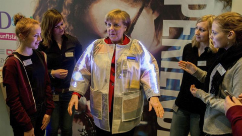 La canciller alemana, Angela Merkel, se prueba una chaqueta inteligente diseñada a prueba de carteristas y que informa de la temperatura durante el Día de las Chicas en la Cancillería Federal en Berlín, Alemania. EFE/Kay nietfeld