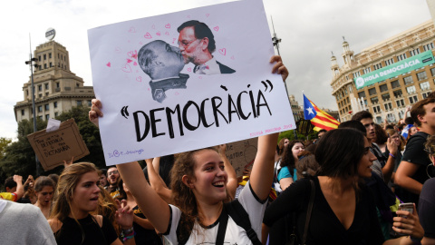 Una mujer sostiene un cartel que muestra al presidente de Gobierno, Mariano Rajoy, y al dictador Francisco Franco, sobre el mensaje "Democracia", durante la manifestación en repulsa de las escenas de violencia policial que se vivieron el 1- Una mujer sostiene un cartel que muestra al presidente de Gobierno, Mariano Rajoy, y al dictador Francisco Franco, sobre el mensaje "Democracia", durante la manifestación en repulsa de las escenas de violencia policial que se vivieron el 1-