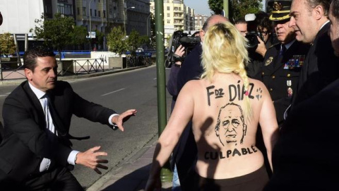 Una activista de Femen protesta contra le 'ley moprdaza' frente al entonces ministro del Interior, Jorge Fernández Díaz, en Madrid en 2015.- AFP