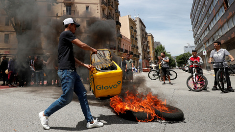 Un repartidor de Glovo quema una mochila durante una protesta tras la muerte de un compañero en Barcelona.-REUTERS/ALBERT GEA Un repartidor de Glovo quema una mochila durante una protesta tras la muerte de un compañero en Barcelona.-REUTERS/ALBERT GEA